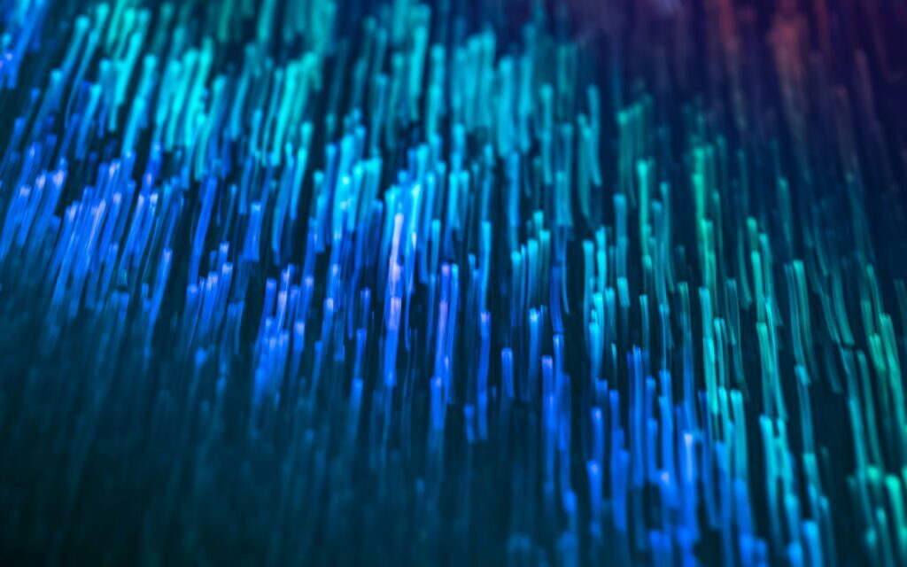 Abstract visualization of flowing blue and teal light streaks resembling fast-moving data streams or fiber optic signals.