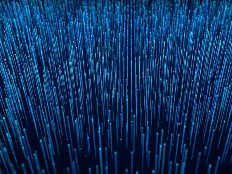 Abstract vertical blue light streaks resembling fiber optic strands on a dark background.