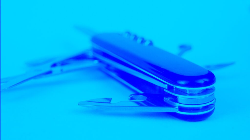 A photo of a Swiss Army knife with a blue overlay. The Swiss Army knife represents how much better it is to consolidate to one tool that does many things instead of having separate tools that spread resources.