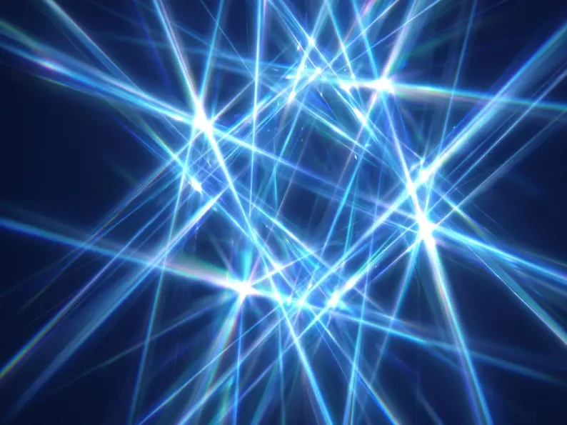 Abstract intersecting blue light beams with bright star-like flares on a dark background.