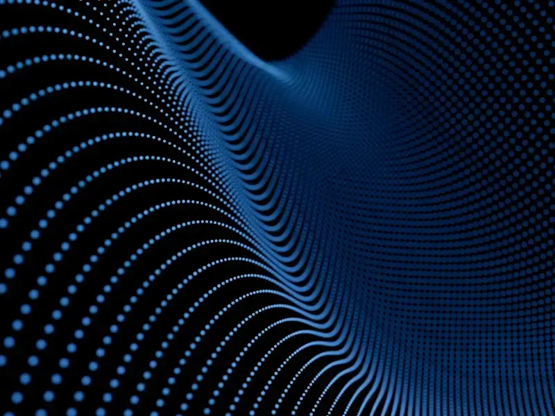 Abstract blue wave pattern made of dotted particles on a black background, representing digital data flow.
